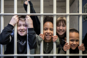 Children smile from behind prison bars