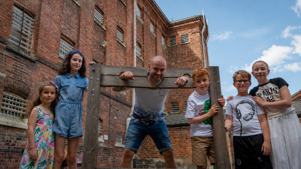 Shrewsbury Prison - Summer Family Offer: Kids Go Free and Eat Free - dad with kids in Shrewsbury prison playing outside - pillory